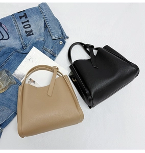 Detailed close-up of textured leather handbags in black and khaki with minimalist handles