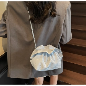 Detail of light blue ruched cloud bag with sparkling rhinestones and silver chain strap