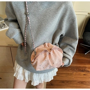 Close-up of pink pleated cloud bag with silver rhinestones and adjustable metal chain