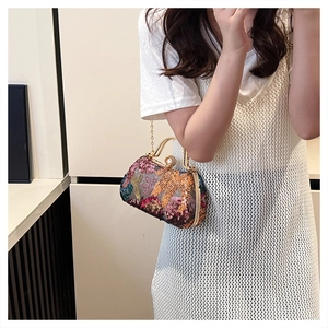 Close-up of vintage evening bag with colorful sequins, gold handle and large pearl clasp