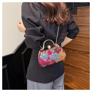 Detailed view of luxury sequin evening clutch featuring colorful floral patterns and pearl clasp