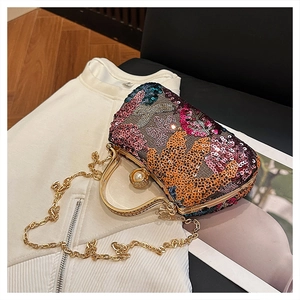 Detail of colorful sequin evening bag with butterfly motif and golden metal handle