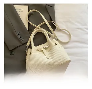 Détail du sac à main tissé crème avec garniture en cuir et boucle métallique chic