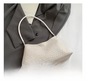 Close-up of cream white woven leather texture on a retro shoulder bag with woven handle
