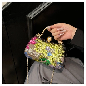 Detail of colorful sequined evening clutch with gold metal handle and pearl clasp