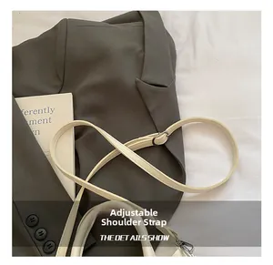 Détail de la bandoulière réglable en cuir blanc avec boucle argentée sur le sac chic