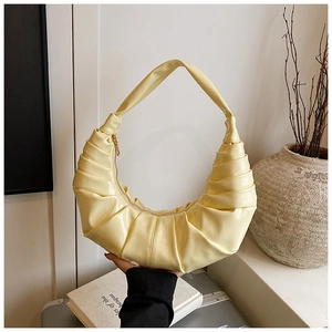 Détail du sac croissant plissé jaune avec finition lisse et fermeture éclair dorée