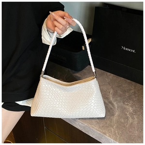 Close-up of white woven leather baguette bag with matching braided handle for women