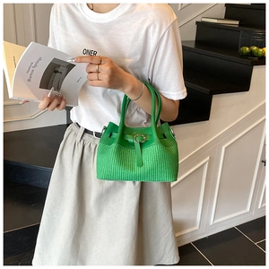 Détail d'un sac à main vert vif avec texture tressée et boucle en cuir élégante