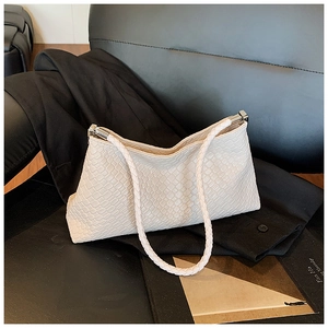 Detail of cream white faux crocodile leather shoulder bag with silver metal buckles