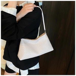 Close-up of white woven texture and handle on a minimalist vintage underarm bag