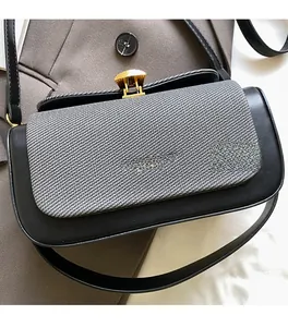 Detail der quadratischen Tasche mit grauer Webstruktur und goldenem Fächerschloss