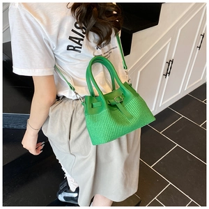 Détail de la texture tissée verte et des coutures en cuir PU de ce sac à bandoulière chic
