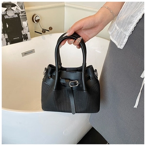 Détail du sac cabas noir présentant un contraste de cuir lisse et de texture tressée