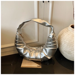 Détail d'un sac demi-lune plissé argent métallique avec fermeture éclair élégante