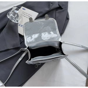 Detail view of silver shiny crossbody bag featuring double compartments and internal zipper