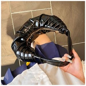 Détail du sac croissant plissé noir en cuir verni brillant avec fermeture éclair en métal