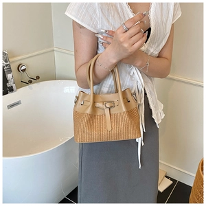 Détail du sac seau en paille tissée et cuir avec boucle en métal argenté en intérieur