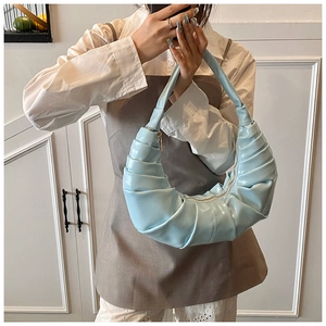 Gros plan détaillé d'un sac croissant plissé bleu clair au fini similicuir brillant