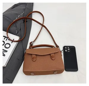 Brown crossbody bag size comparison with a smartphone showing internal storage capacity