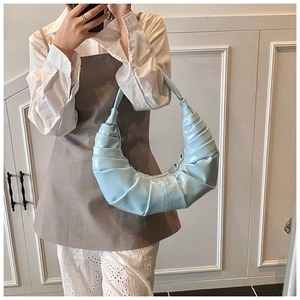 Vue détaillée du sac croissant plissé bleu clair porté comme un sac à bandoulière