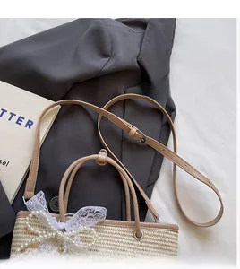 Detail of straw woven tote with elegant pearl lace bow and adjustable leather strap