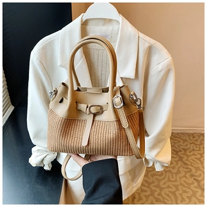 Détail du tissage en paille et cuir marron sur un sac seau avec deux poignées