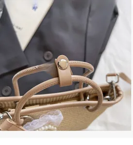 Detail of straw bag featuring leather handles with white lace and pearl accents