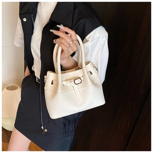 Détail d'un sac seau blanc présentant une texture en cuir et un tissage en losange
