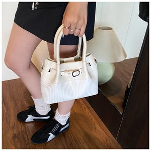 Détails d'un sac à main blanc en cuir avec textures mixtes et boucle métallique élégante