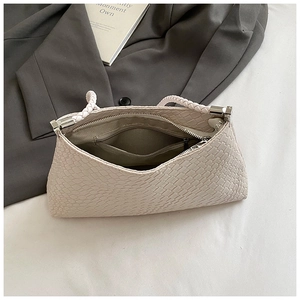 Detail view of the beige crocodile pattern bag interior with zipper pocket and lining