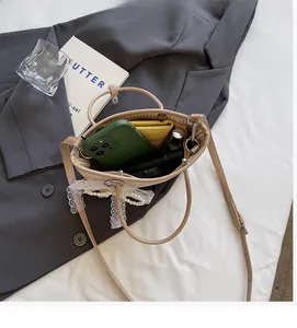 Straw handbag detail showing interior space for phone, wallet and cosmetics with bow accent