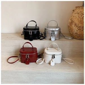 Schicke Retro-Box-Taschen in Schwarz, Silber, Burgund und Weiß auf steinernen Treppenstufen