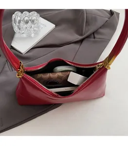 Internal capacity of dark red crescent shoulder bag showing phone and wallet