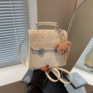 White mini backpack with sparkling rhinestones and a plush bear pendant charm