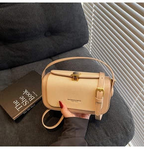 Detail der beige Ledertasche mit goldenem Muschelverschluss und Strukturpaneelen