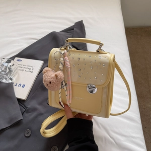 Yellow faux leather crossbody bag with silver rhinestones and bear charm detail