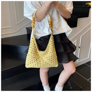 Détail du sac à main jaune crocheté à la main avec poignée élégante en perles de bois
