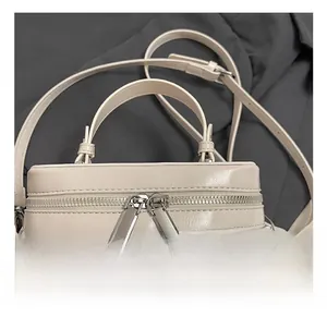 Detailaufnahme des silberfarbenen Doppelreißverschlusses an der glänzenden Lederhandtasche