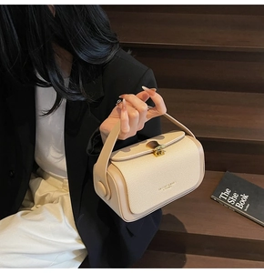 Schicke cremefarbene kleine Tasche mit goldenem Muschelverschluss und Ledertextur