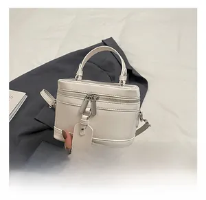 Detailaufnahme der weißen Box-Handtasche mit silbernen Reißverschlüssen und Lederstruktur