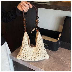 Détail du sac à bandoulière tissé creux avec poignées en perles de bois marron foncé