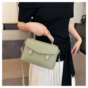Detail showing the light green twill fabric texture and button design of this messenger bag