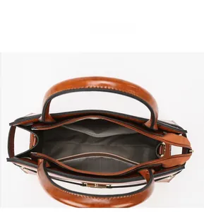 Macro view of the spacious internal compartments and grey fabric lining of a vintage brown tote