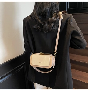 Detail der beige farbenen Ledertasche mit Litschi-Maserung und goldener Schnalle