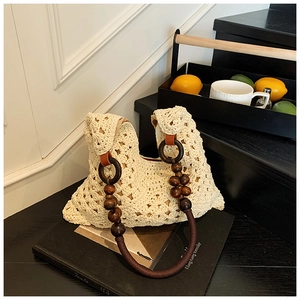 Détail du sac cabas au crochet avec poignées en perles de bois et motifs ajourés beiges