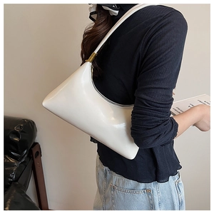 Side view of white glossy faux leather crescent shoulder bag with golden buckle details