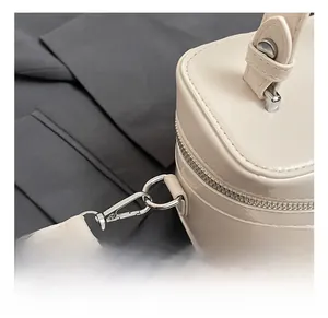Nahaufnahme hochwertiger Silberhaken und Metallteile an einer cremefarbenen Box-Tasche