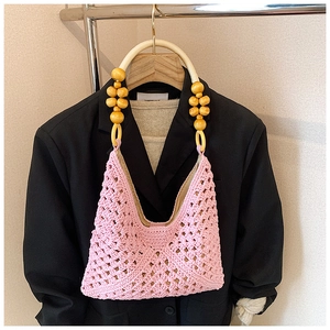 Détail du sac tissé au crochet rose avec perles en bois et anse à nœud