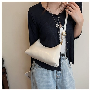 Detailed side view of the cream crescent hobo bag with gold hardware on model